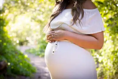 Une femme enceinte dans une robe blanche