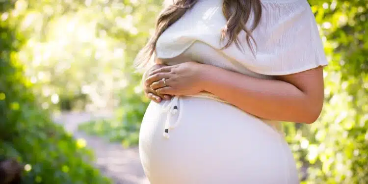 Une femme enceinte dans une robe blanche