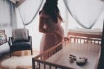 Une femme enceinte préparant la chambre de son futur bébé