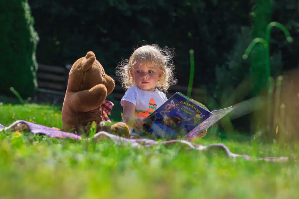 Un enfant qui lit dans un pré